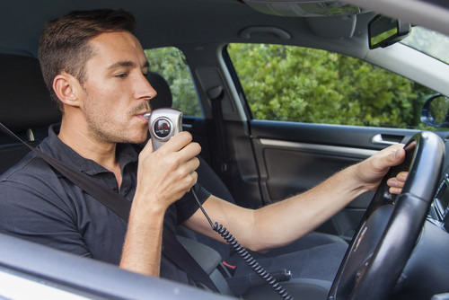 Man breahting into ignition interlock device
