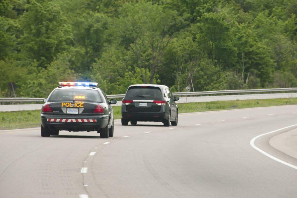 Police car with lights activated initiating a traffic stop of a vehicle - felony vehicular eluding is a serious crime in Colorado