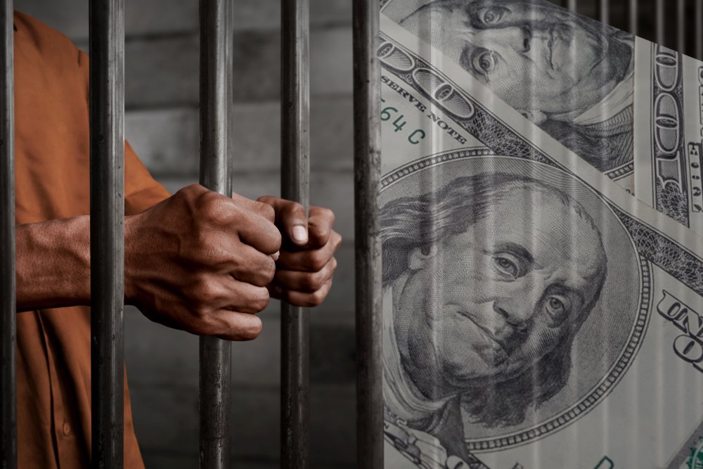 hombre tras las rejas y billete de 100 dólares
