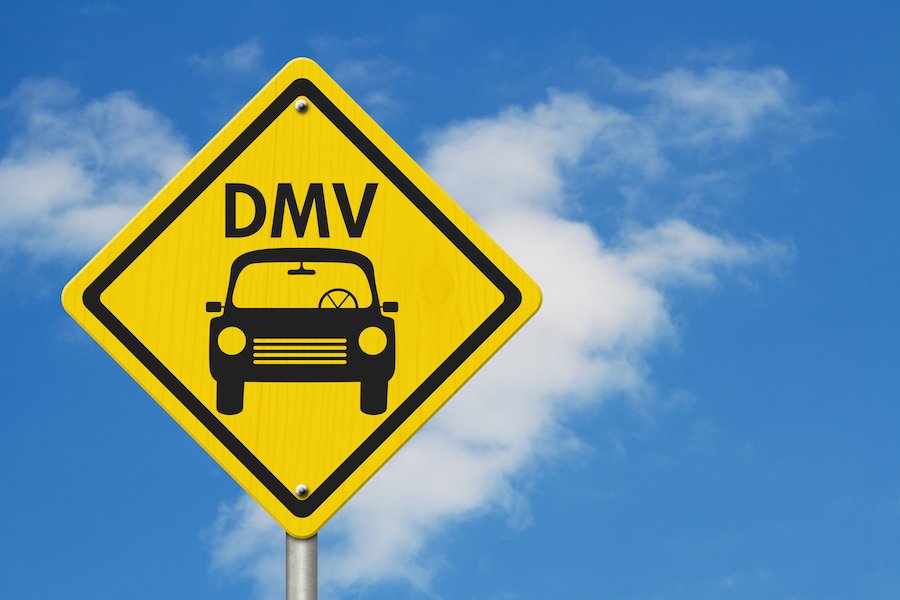 DMV sign against blue sky with clouds