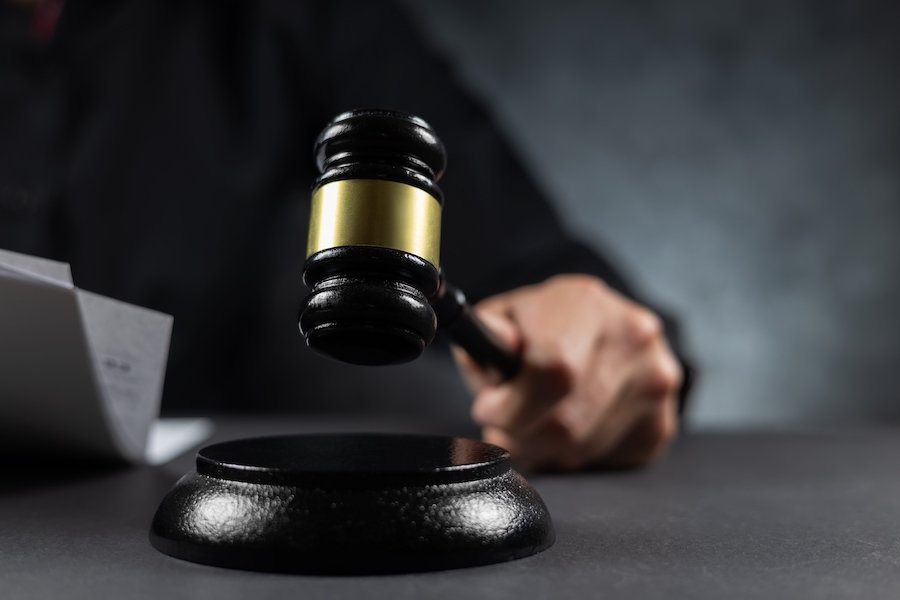 Judge hammering down a gavel at the bench following an obscenity trial