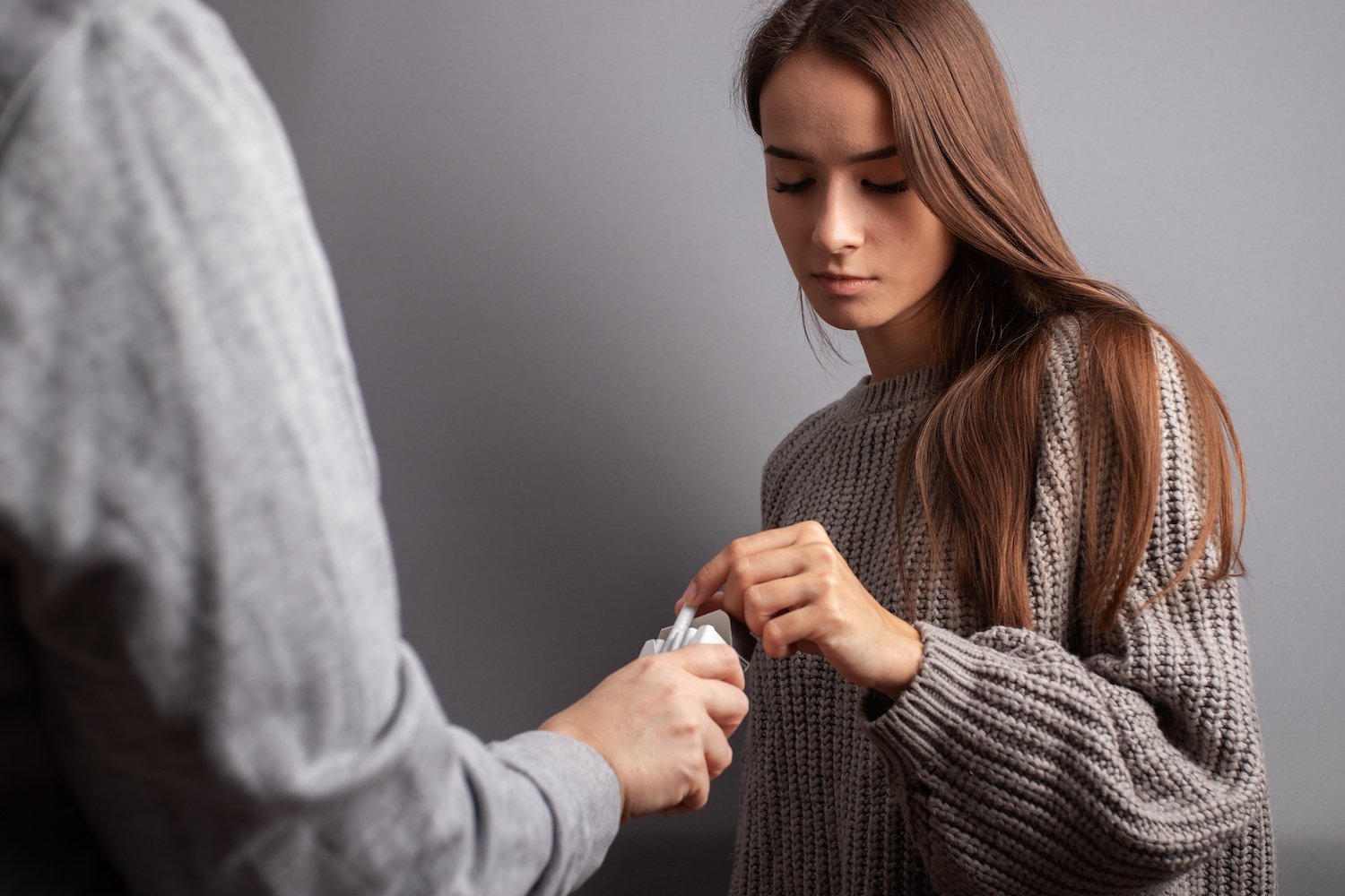 Adolescente joven tomando cigarrillos de un extraño con malas intenciones