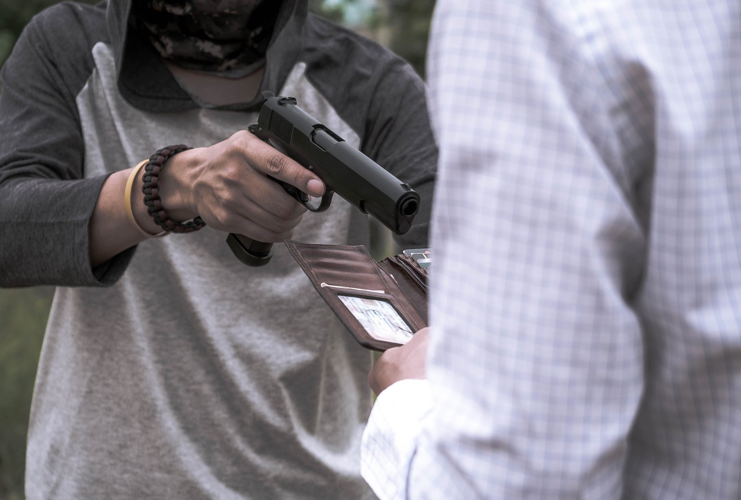 Hold-up scene where a robber is demanding the victim's wallet