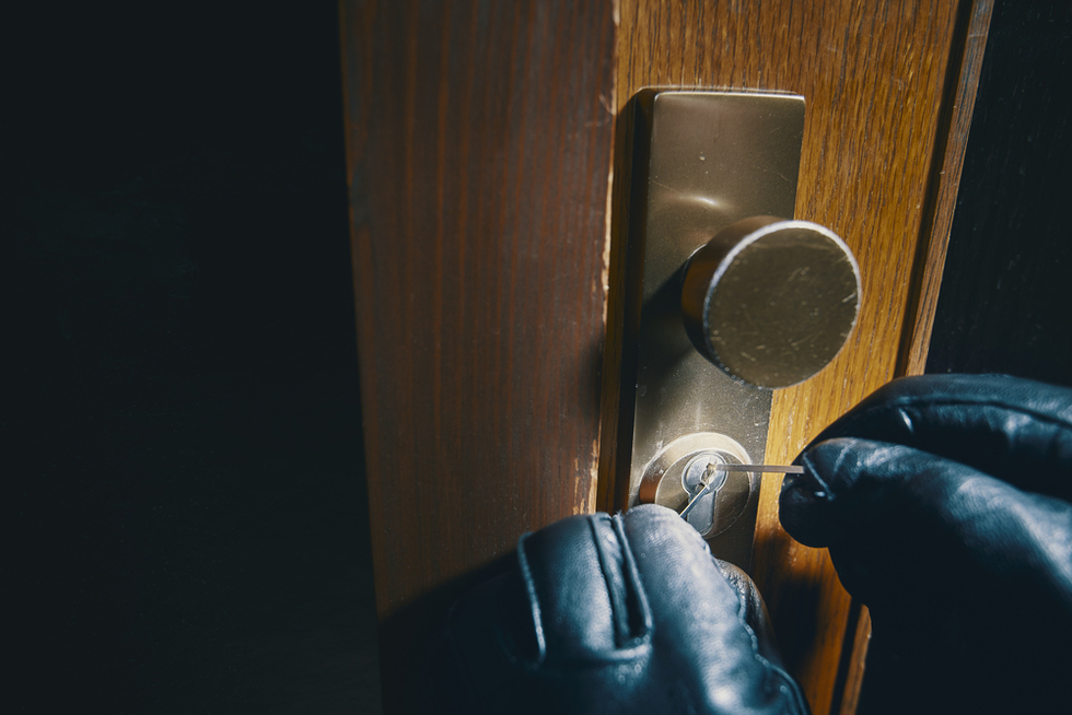 burglar with gloves on picking a lock to a front door as an example of second-degree burglary per Colorado CRS 18-4-203