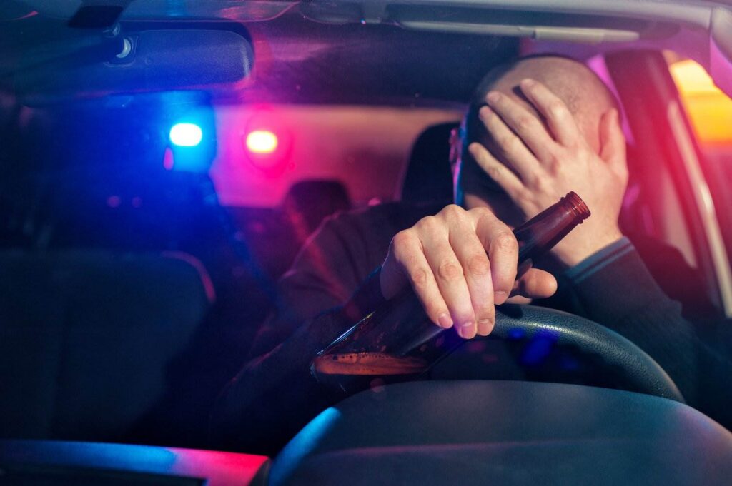 Driver holding beer bottle while being tailed by police