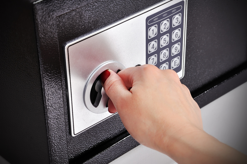 woman's hand opening a safe as an example of what could be third-degree burglary per Colorado CRS 18-4-204