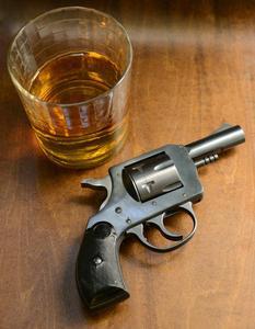Pistol next to a shot of whiskey