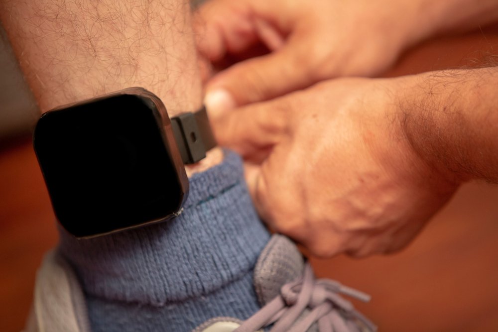 An ankle monitor being put on a man's ankle as a condition of bail