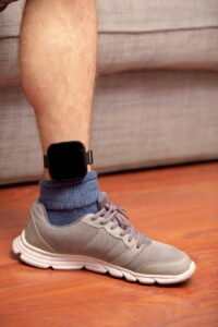 Ankle with an electronic monitoring bracelet, which many defendants are required to wear during house arrest in Colorado