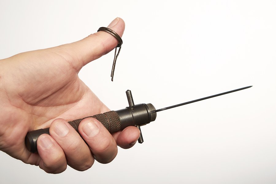 Man's hand holding a knife in front of a white background