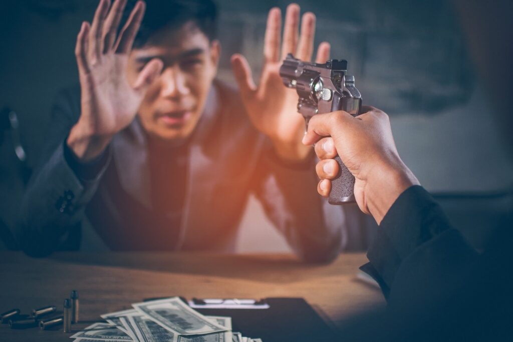 Hand holding gun in direction of a victim as an example of extortion per C.R.S. 18-3-207