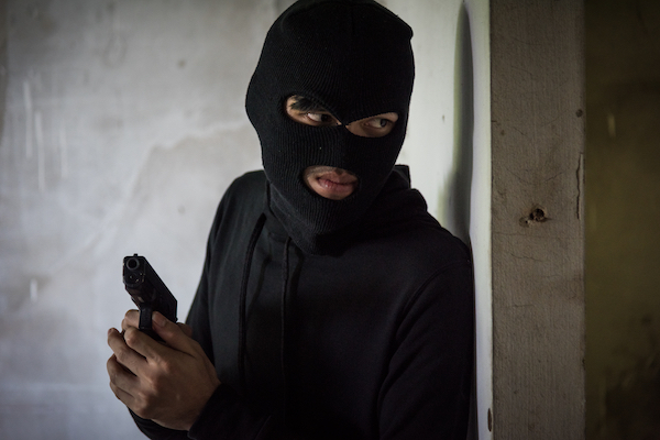 Burglar carrying a gun while trespassing. Since he is armed, it is first-degree burglary in Colorado. 