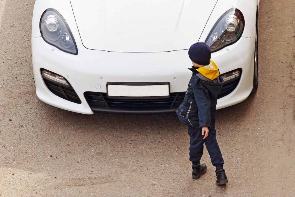 Absent-minded child in front of a car trying to aovid him. 