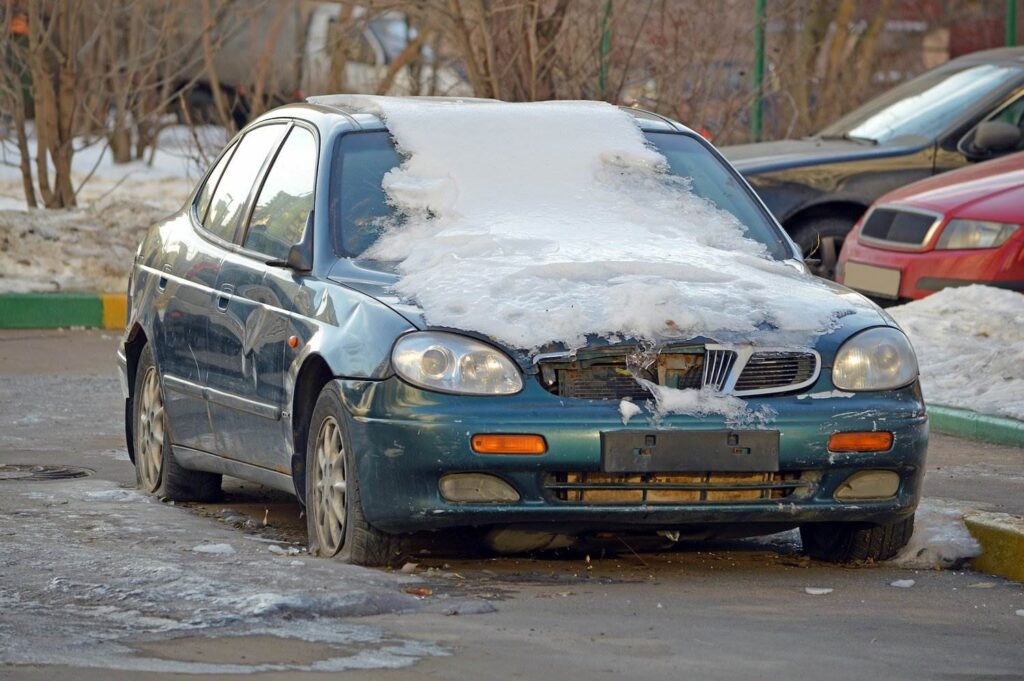 Snow-covered sedan without a front license plate in violation of CRS 42-3-202