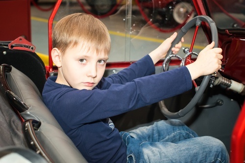 Child holding steering wheel