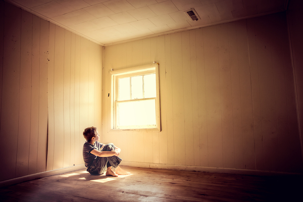 A Colorado child abuse victim, hungry and alone in an empty spare room looking out the window