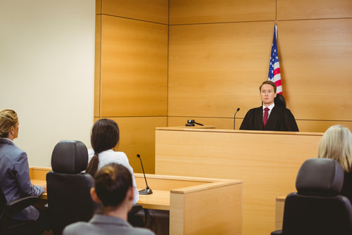 Judge presiding over a courtroom hearing where a defendant is arguing for a motion for reconsideration