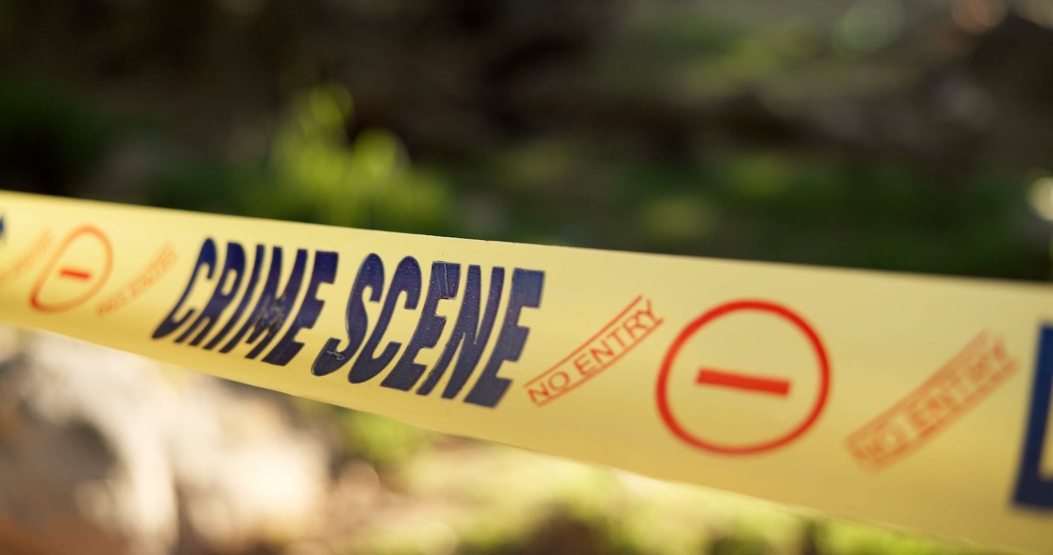 Yellow crime scene tape cordoning off an outside area