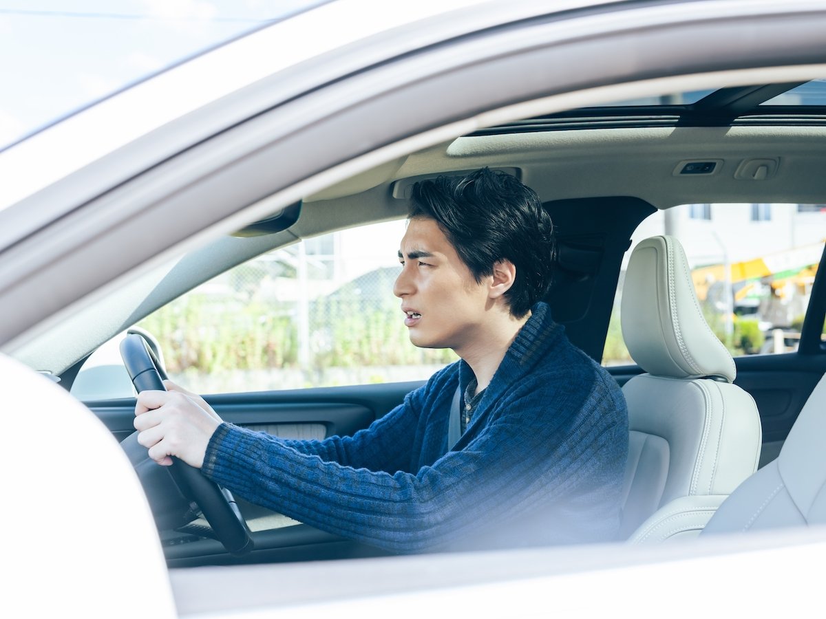 Angry driver in a sedan after seeing a DUI checkpoint in the distance