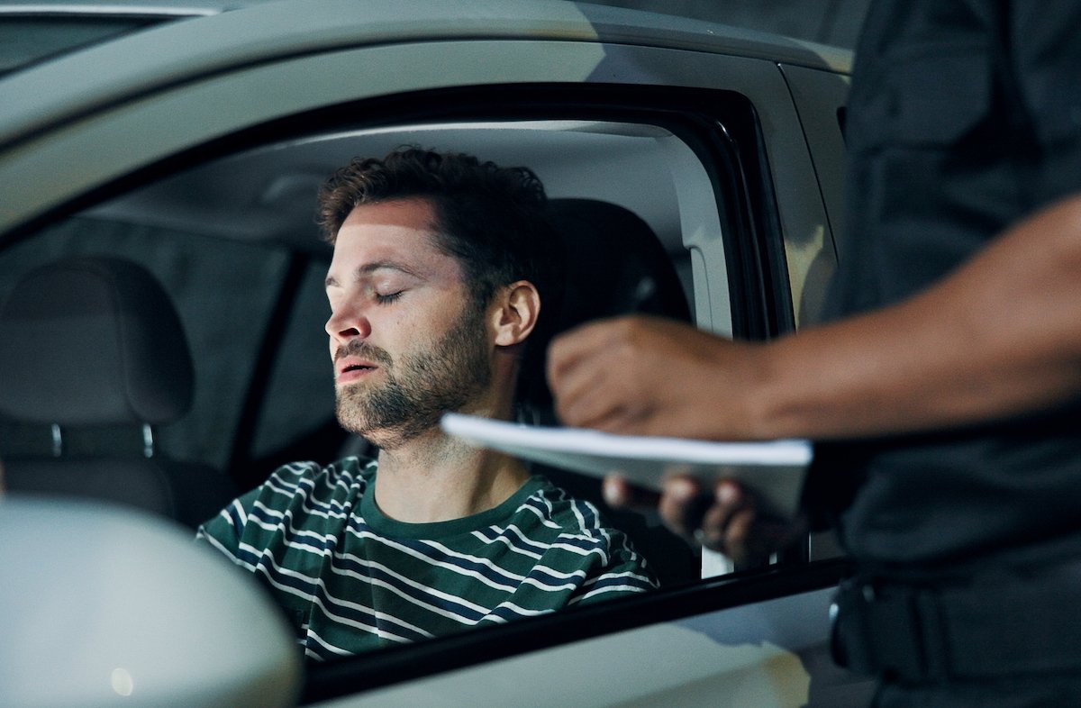 Traffic stop with the driver looking dejected as the police conducts a DUI investigation