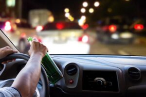 Truck driver in truck holding beer