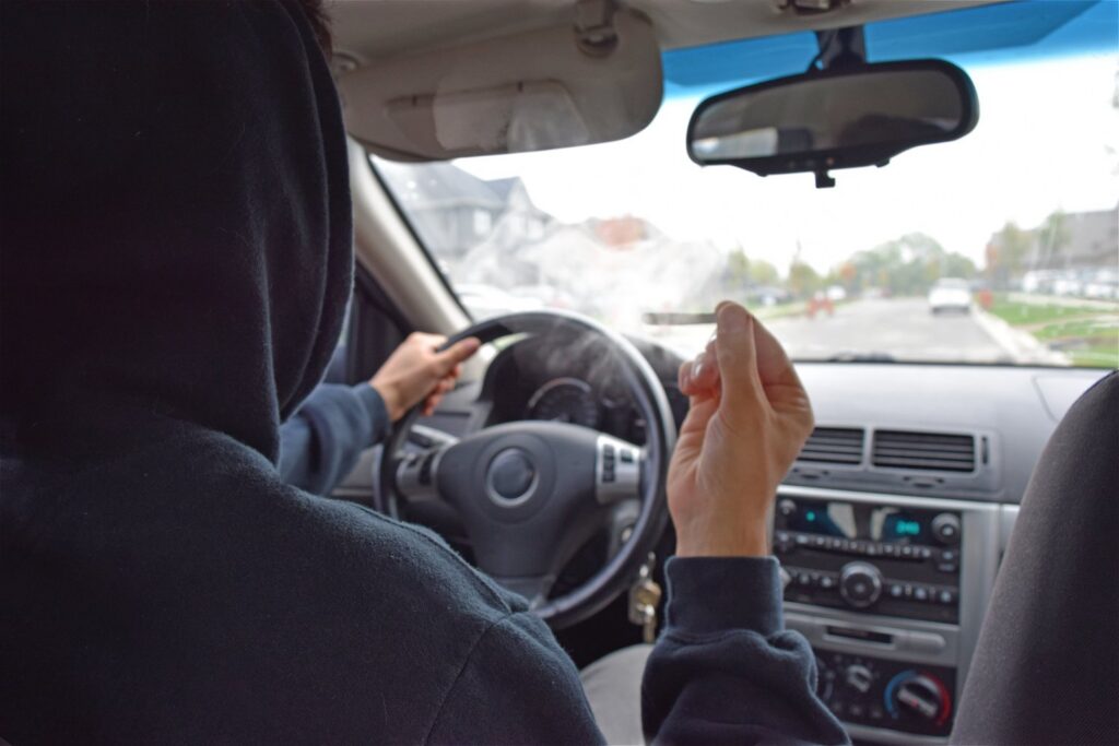 Hooded driver holding a joint