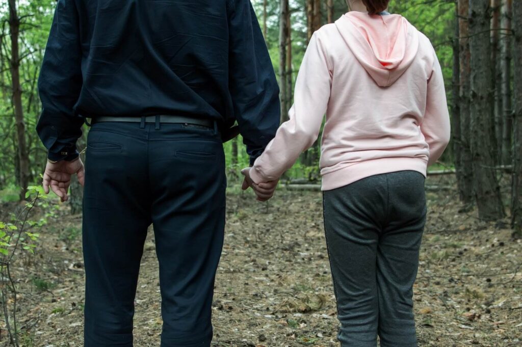 An older man enticing a child into the woods 