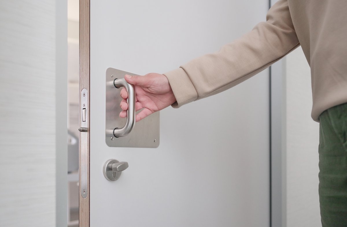 Man opening a door, signifying he is free to leave