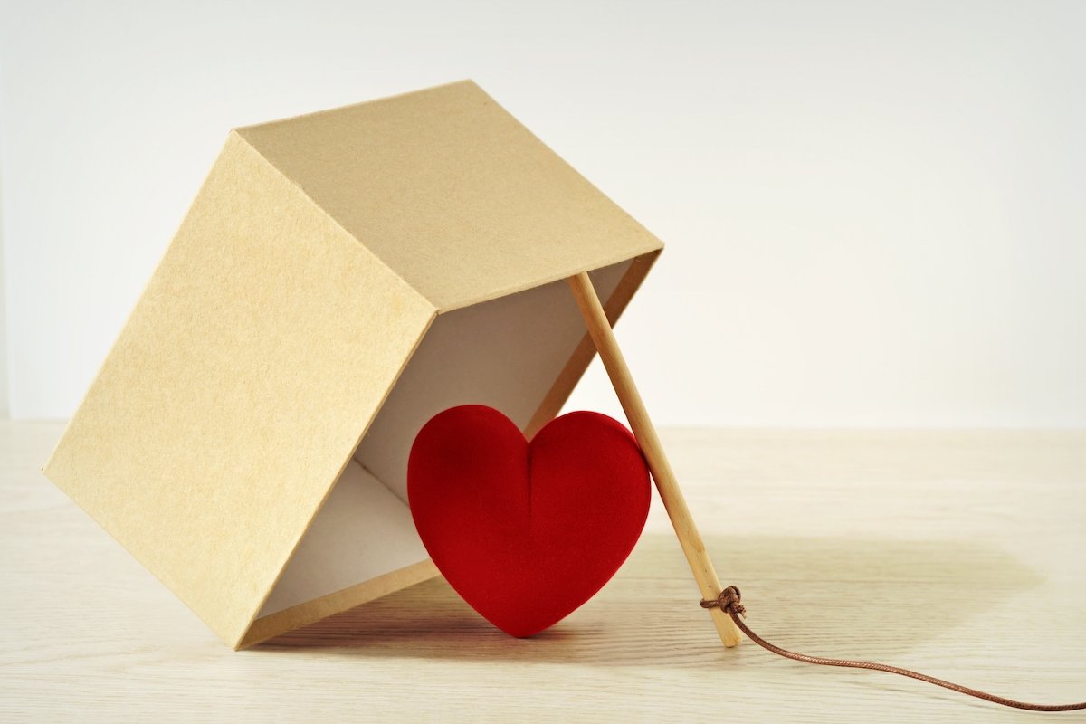 Tilted box about to trap a heart, which is symbolic of falsely imprisoning a love interest in an act of domestic violence