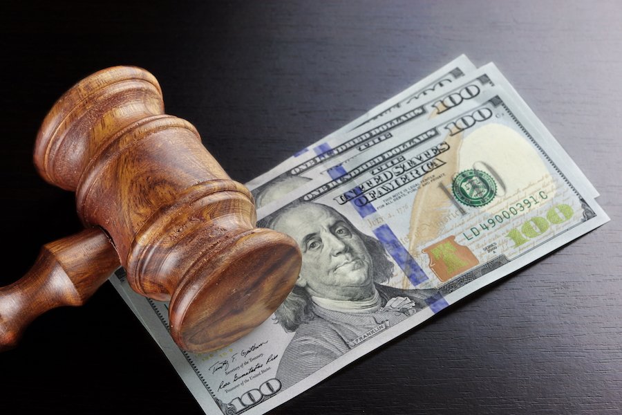 Gavel on top of stack of $100 bills on a black table