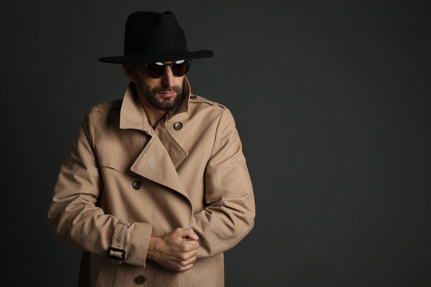 Flasher in a trench coat and sunglasses against a dark background about to violate C.R.S. 18-7-301