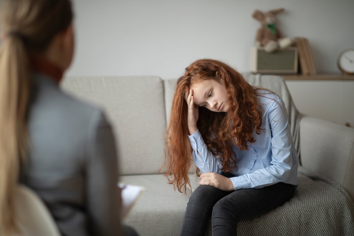 Therapy session between a sad teen and a counselor
