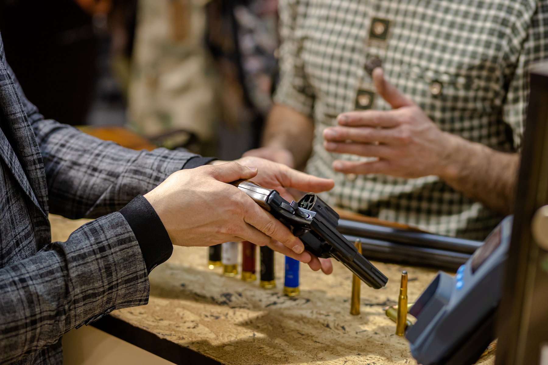 Customer holding handgun at a gun store he is considering purchasing