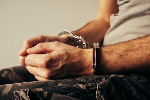 man in handcuffs and military fatigues - Veteran's court in Colorado allows for treatment in lieu of incarceration