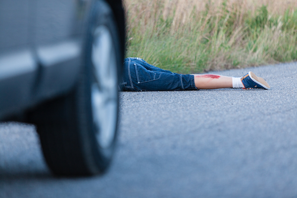 A bloodied pedestrian following a Colorado car accident. The driver could face felony charges for leaving.