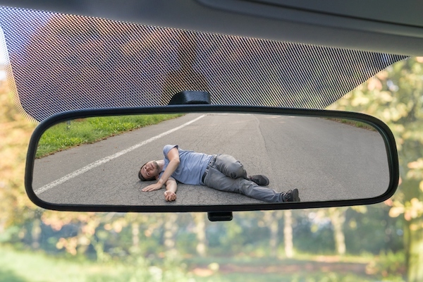 Reflection in visor mirror of a pedestrian hit by a car. The driver has the duty to stop and render aid under CRS 42-4-1603. 