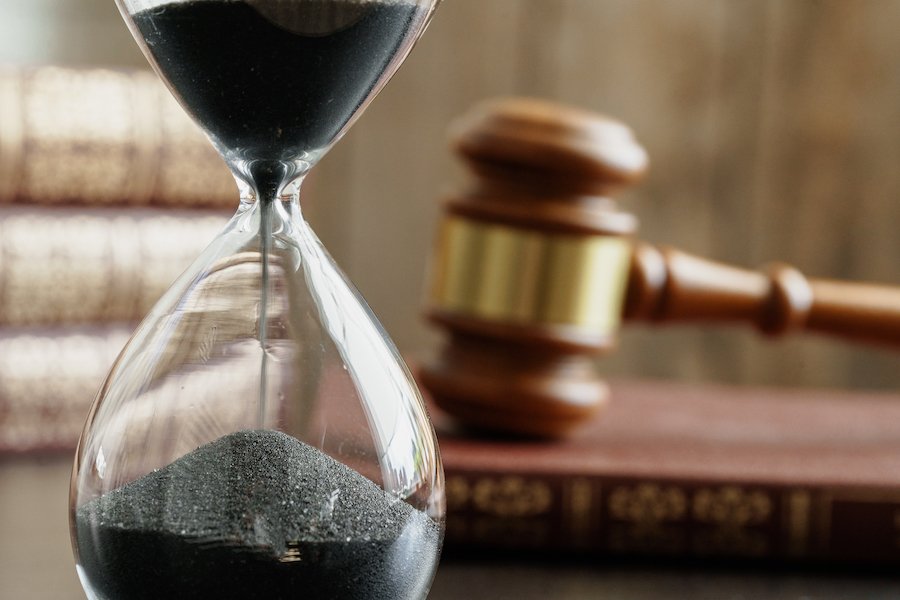 Hourglass and a judge's gavel that symbolizes the statute of limitations to bring criminal charges