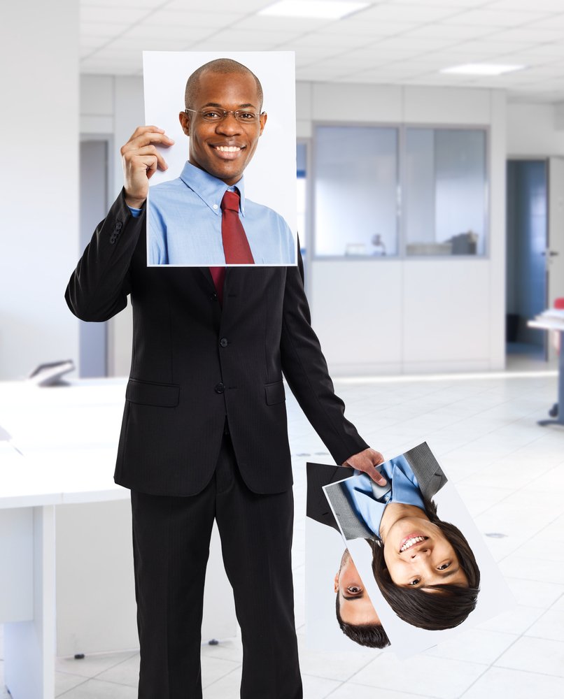 man covering his face with the picture of another