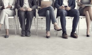 Picture of job applicants in suits waiting to be called in for an interview