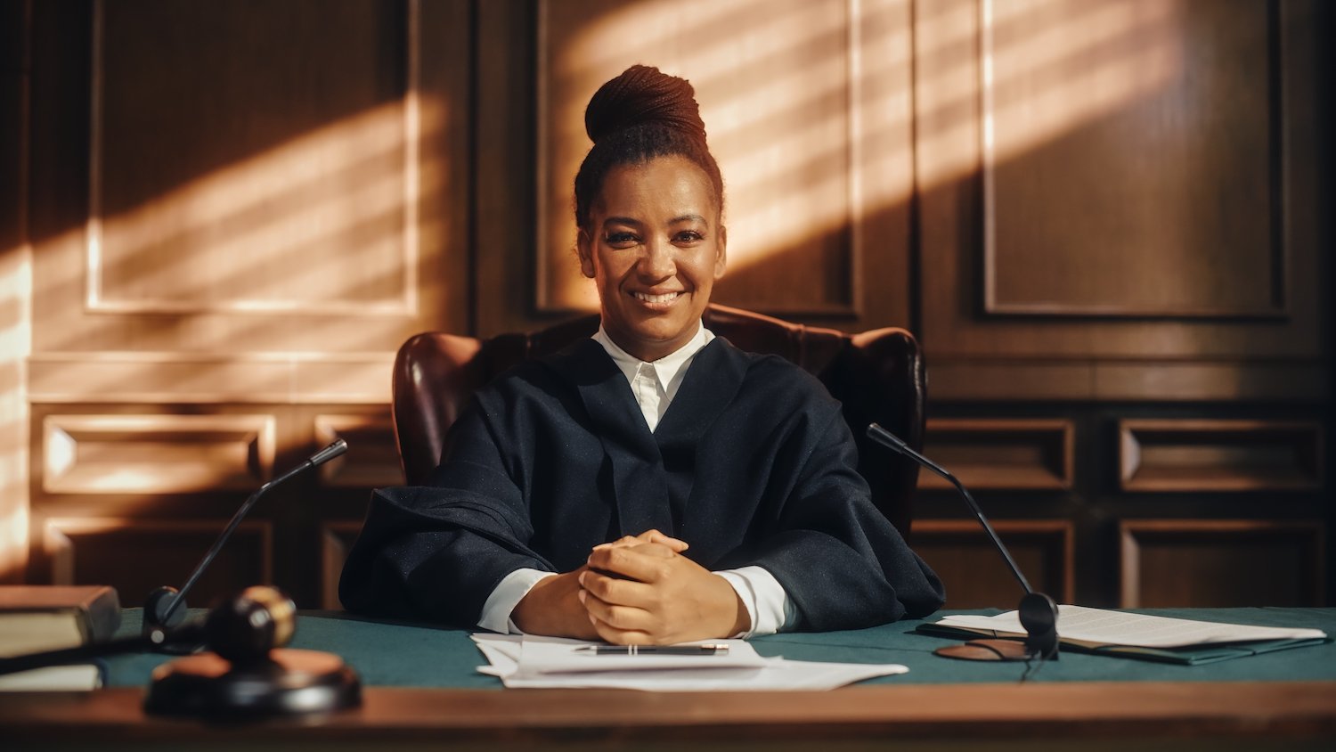 Smiling judge sitting at the bench next to her gavel about to grant a record seal
