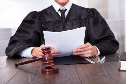 juvenile court judge holding papers at the bench behind his gavel