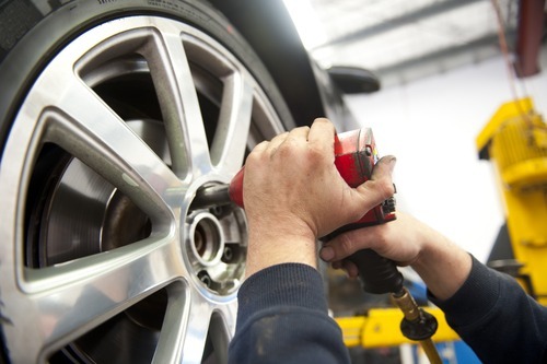 Man touching car tire
