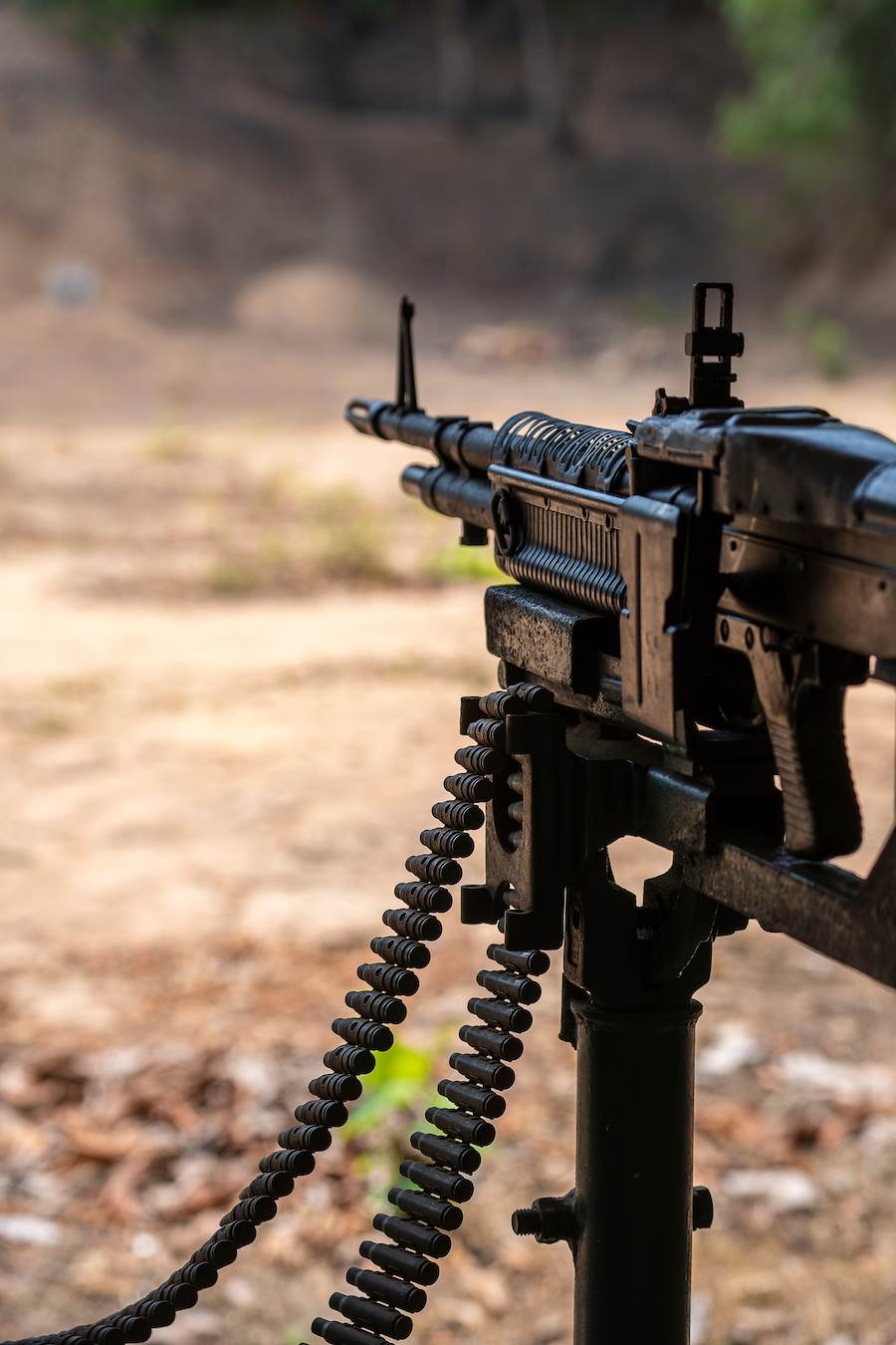 Machine gun positioned on a gun mount against barren background outside