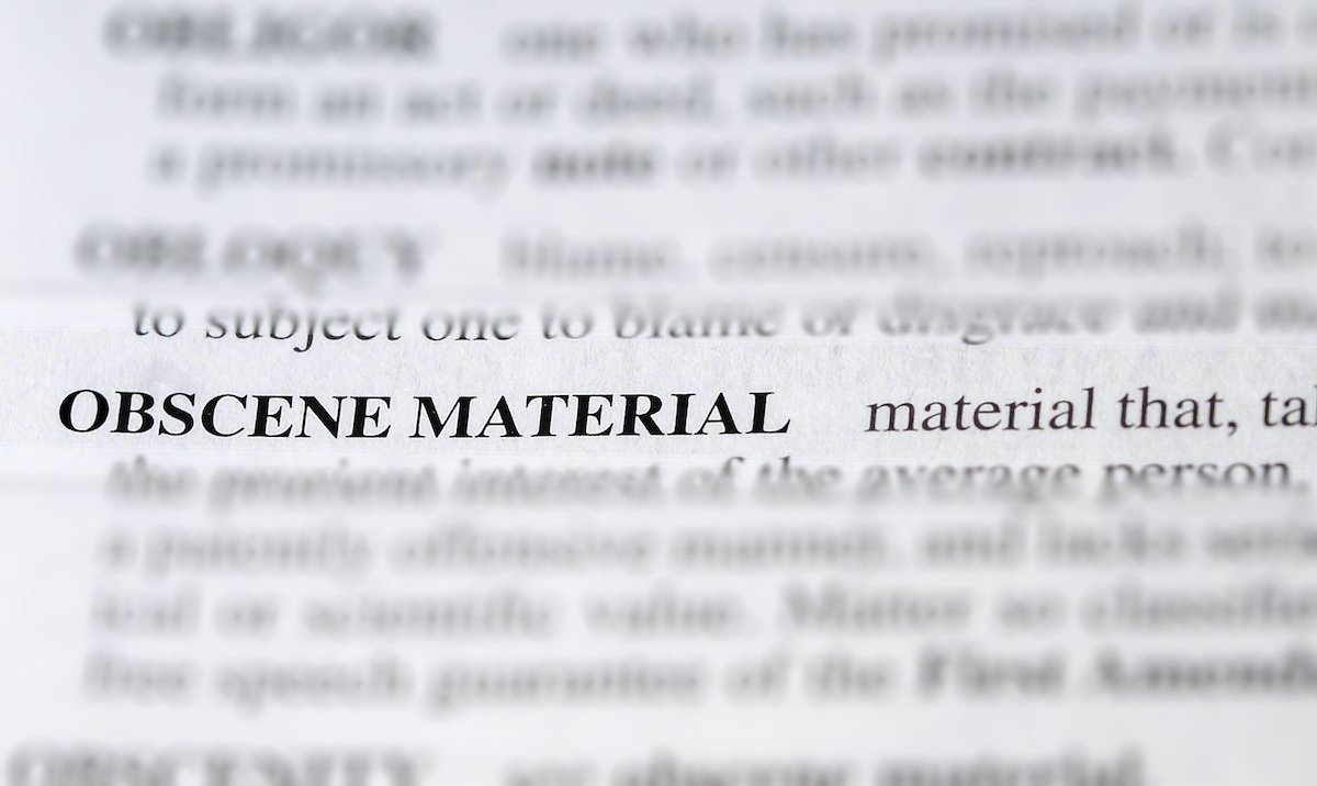 Dictionary page focused on "Obscene Material" with the rest of the page blurred out