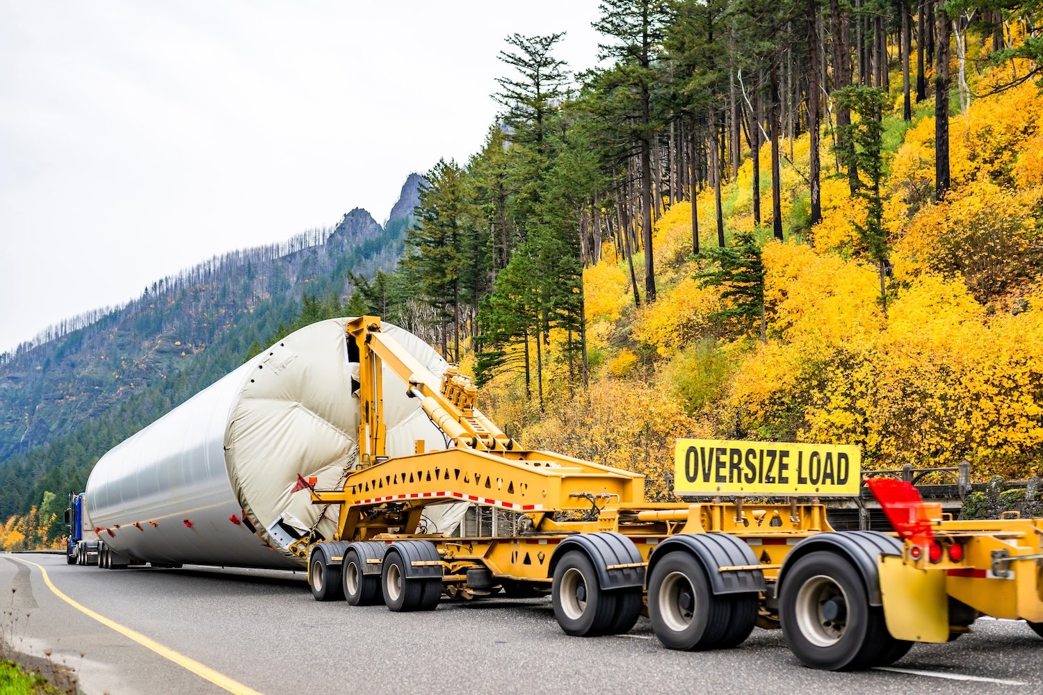 Oversized load truck on a mountain road during and autumn day