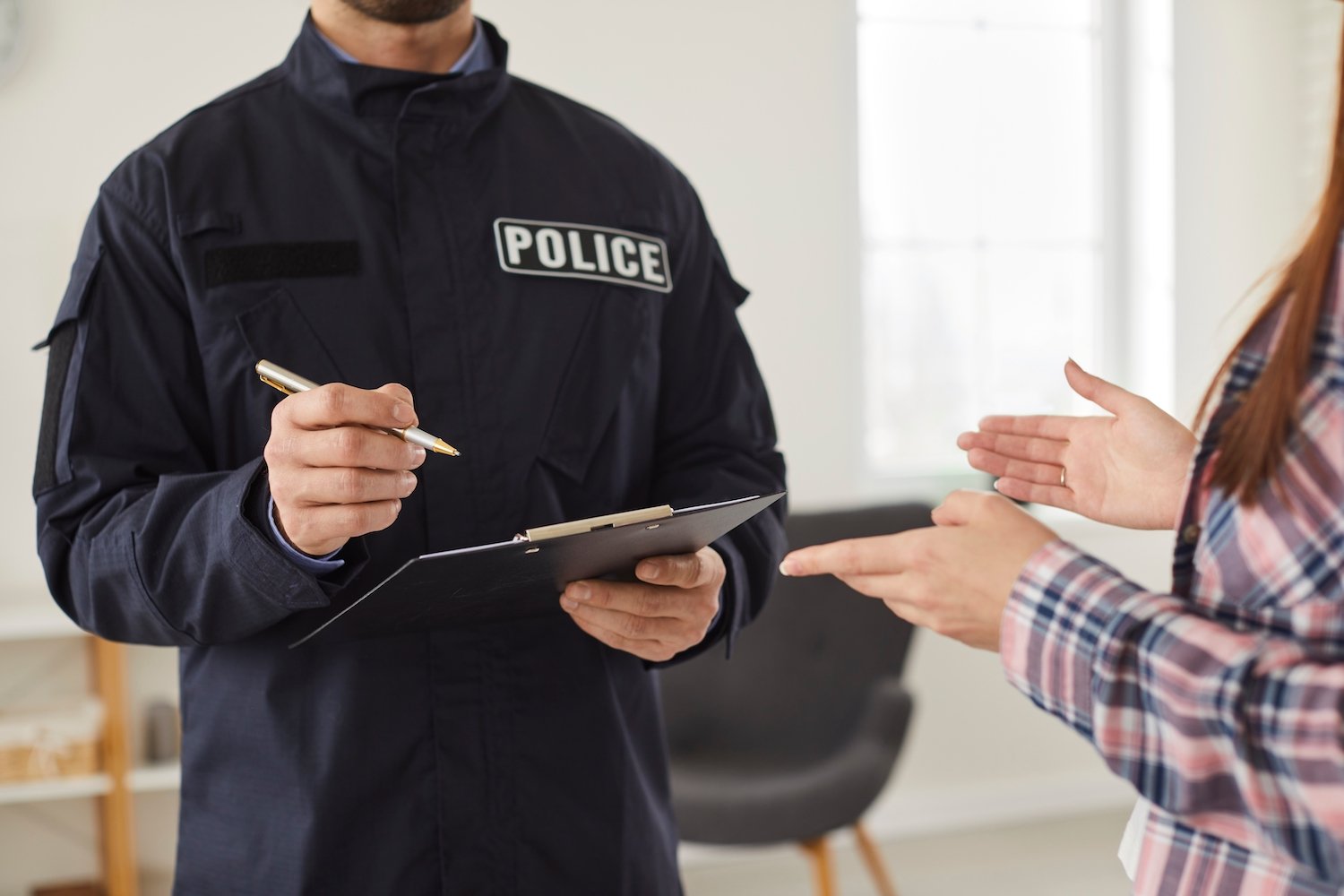 Burglar victim making a police report while an officer holds a clipboard