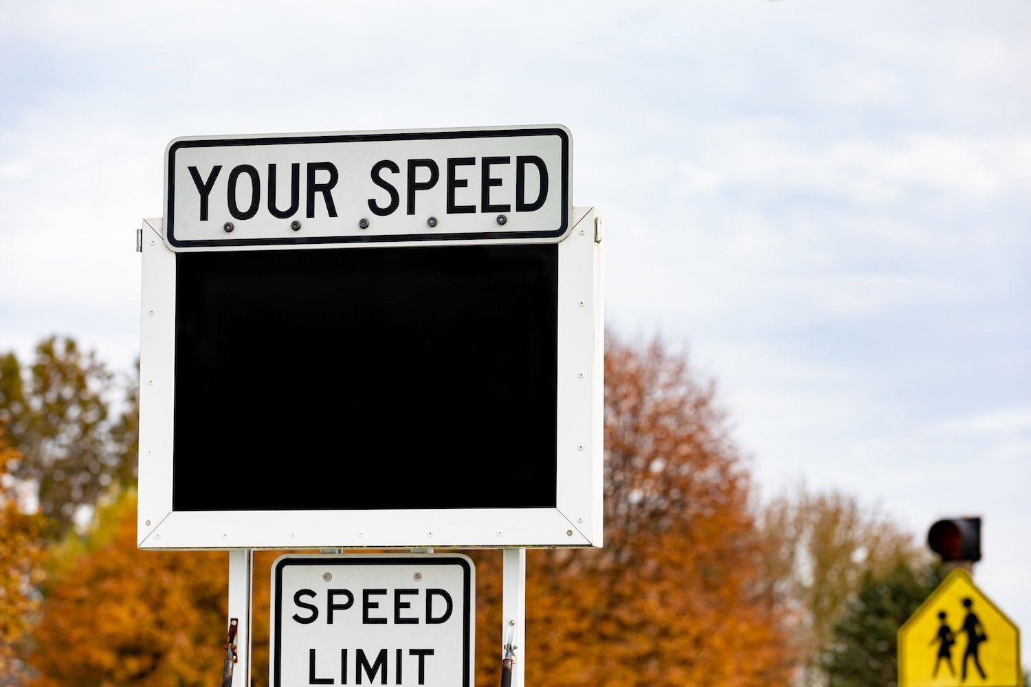 Radar speed sign that says "YOUR SPEED" against a residential neighborhood
