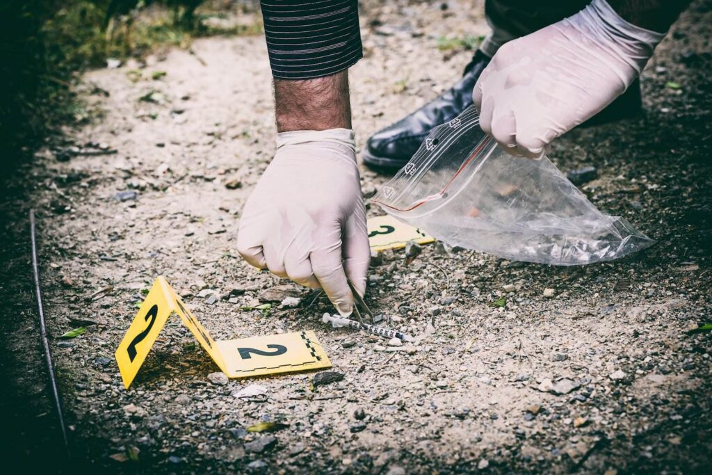 Gloved hand gathering evidence into bag