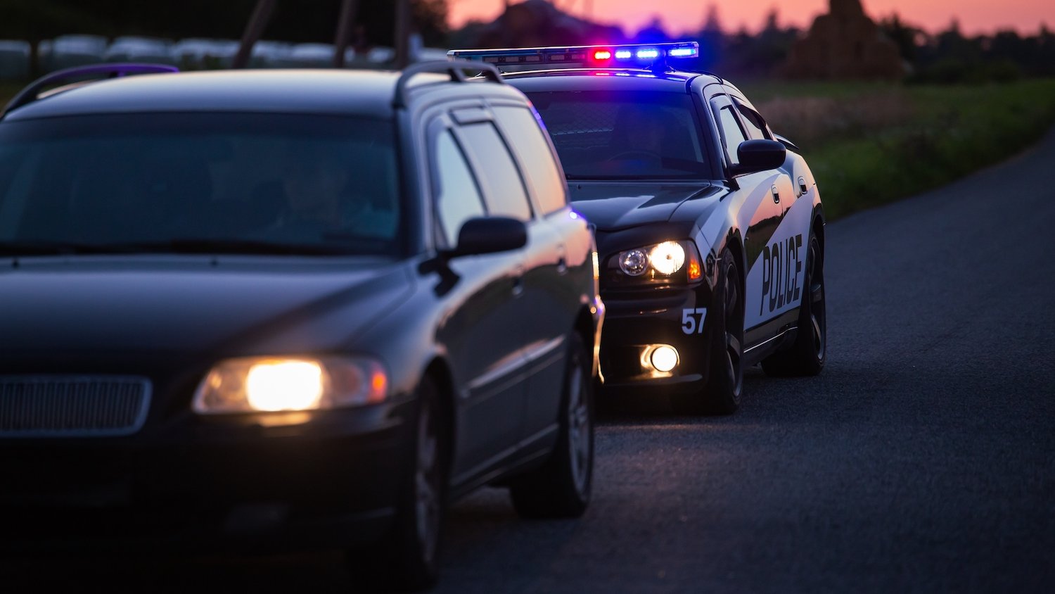 Car pulled over during police traffic stop at dusk on a rural road
