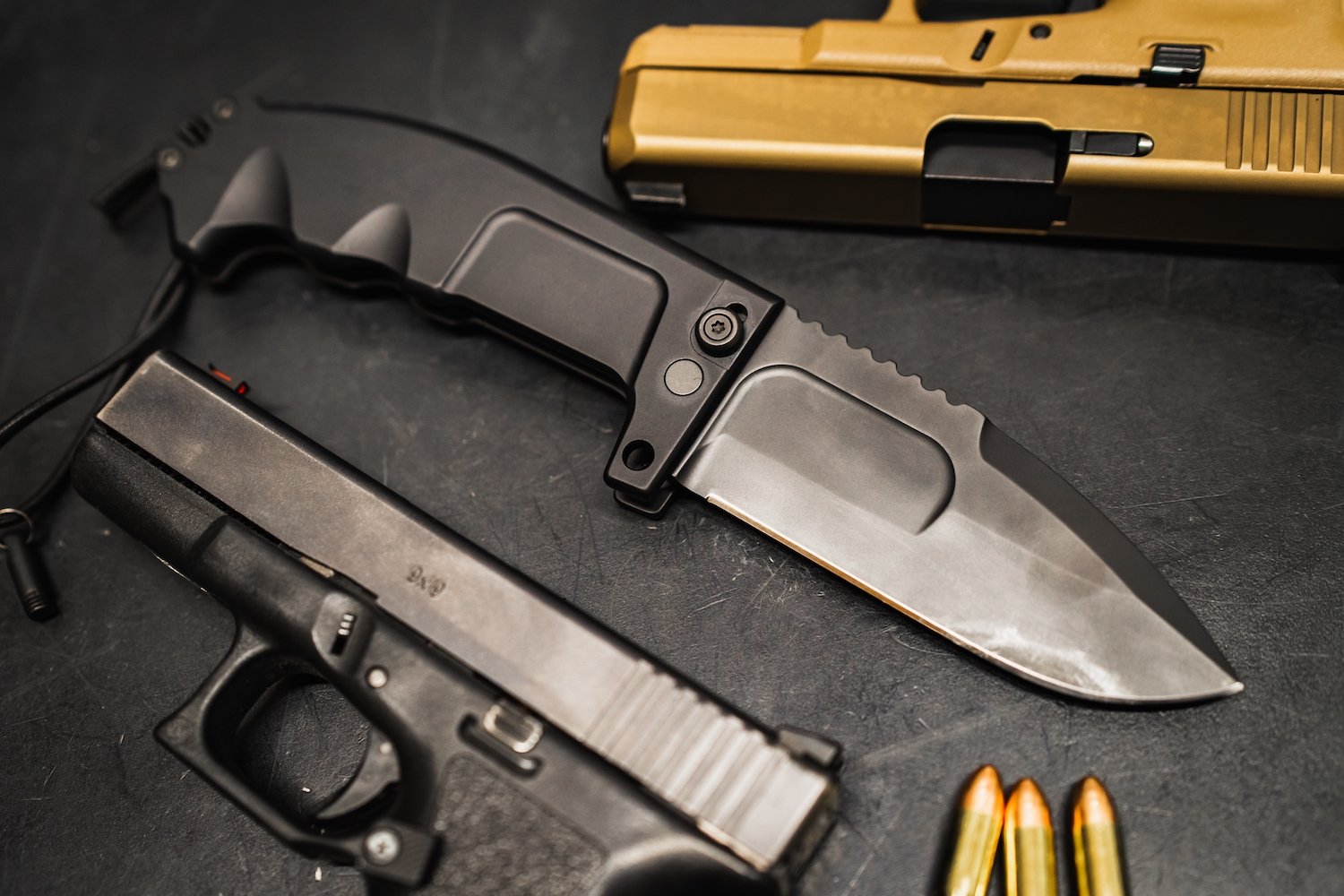 Gun and knife and ammo on a black table, which are weapons that can be used for aggravated robbery